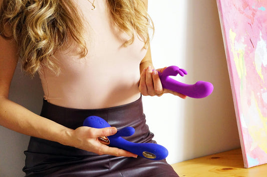 A woman holding a sex toy in each hand